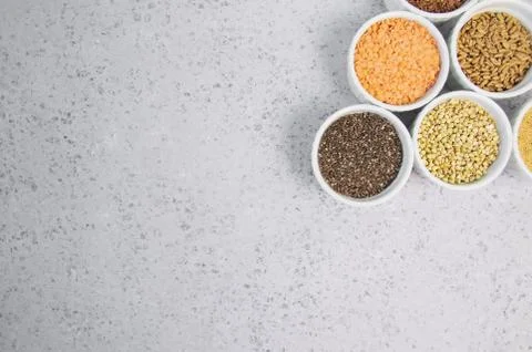 Collection of different groats on grey background. Top view of buckwheat, chia Stock Photos