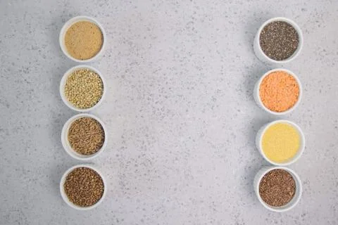 Collection of different groats on grey background. Top view of buckwheat, chia Stock Photos
