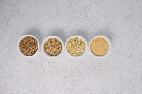 Collection of different groats on grey background. Top view of buckwheat, chia Stock Photos