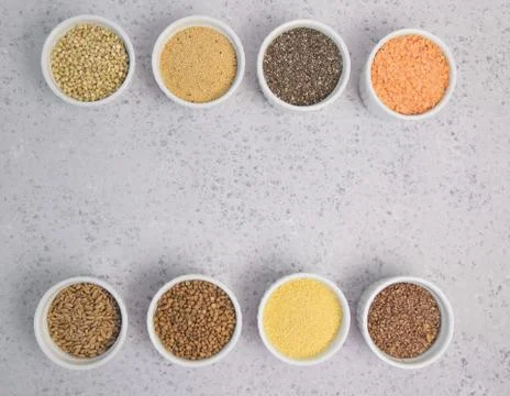Collection of different groats on grey background. Top view of buckwheat, chia Stock Photos