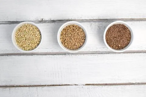 Collection of different groats on grey background. Top view of buckwheat, chia Stock Photos