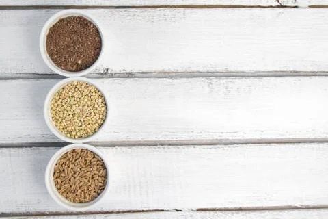 Collection of different groats on grey background. Top view of buckwheat, chia Stock Photos
