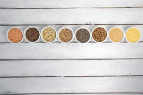 Collection of different groats on grey background. Top view of buckwheat, chia Stock Photos