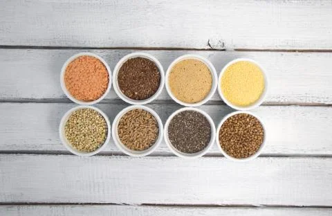 Collection of different groats on grey background. Top view of buckwheat, chia Stock Photos