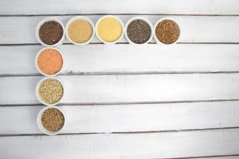 Collection of different groats on grey background. Top view of buckwheat, chia Stock Photos