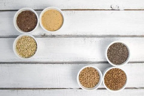 Collection of different groats on grey background. Top view of buckwheat, chia Stock Photos