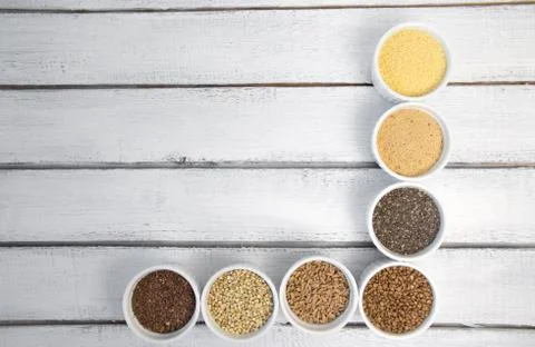 Collection of different groats on grey background. Top view of buckwheat, chia Stock Photos