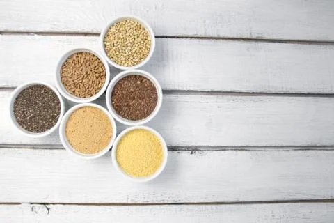 Collection of different groats on grey background. Top view of buckwheat, chia Stock Photos