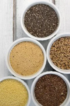 Collection of different groats on grey background. Top view of buckwheat, chia Stock Photos
