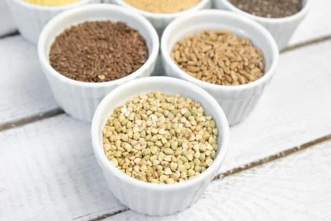Collection of different groats on grey background. Top view of buckwheat, chia Stock Photos
