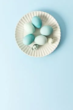 A collection of dyed blue Easter eggs arranged neatly on a white plate sits.. Stock Photos