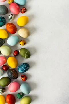 A collection of Easter eggs in bright colors and patterns is displayed on a l Stock Photos