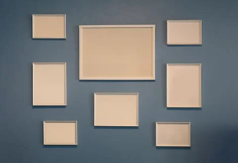 Collection of empty wooden picture frames on a dark blue wall. 스톡 사진
