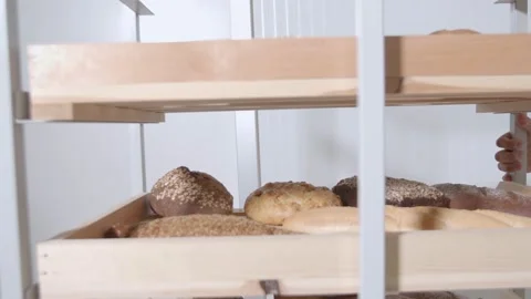 Collection of fresh baked breads is transported on a cart with wooden shelves Stock Footage 153492132