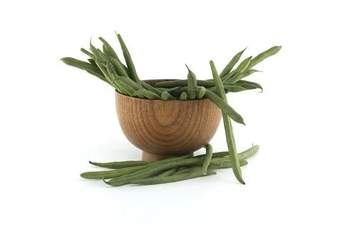 Collection of fresh green beans displayed in wooden bowl on white background. Stock Photos