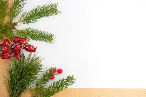 A collection of fresh pine branches and vibrant red berries is neatly arrange Stock Photos