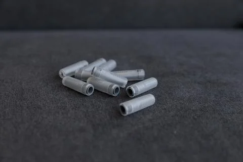 A Collection of Gray Plastic Tubes Spread on a Dark Surface, Ideal for Various Stock Photos