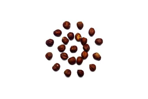 A collection of hazelnut nuts lie in the shape of a circle or sun on an isola Foto stock