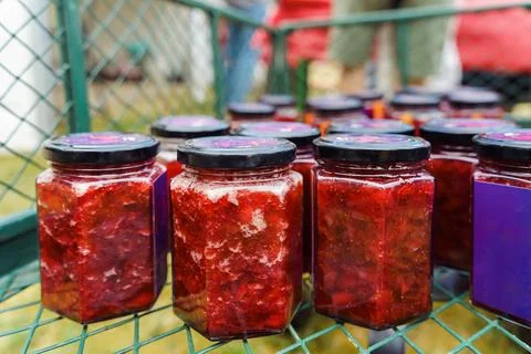 Collection of hexagonal jars with black lids filled with homemade strawberry jam Stock Photos