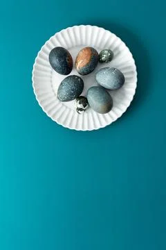 A collection of intricately decorated Easter eggs in various shades rests o.. Stock Photos