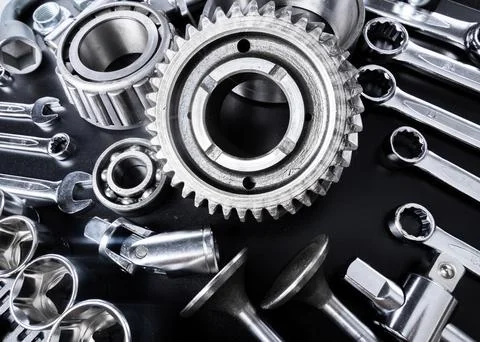 Collection of metallic tools and mechanical components arranged on a black Stock Photos