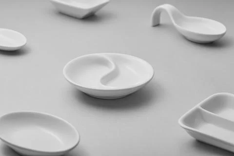 A collection of minimalist white ceramic tableware is arranged on a gray su.. Stock Photos