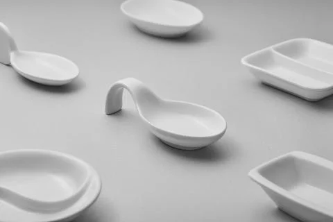 A collection of minimalist white ceramic tableware is arranged on a gray su.. Stock Photos