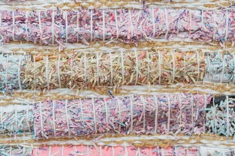Collection of multi-colored, shredded, cylindrical bundles on a flat surface  Stock Photos
