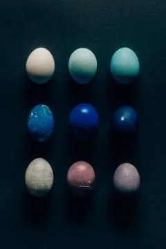 Collection of nine colored painted easter eggs on dark surface 스톡 사진