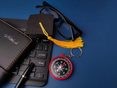 A collection of objects including a notebook, pen, keyboard, graduation cap.. Stock Photos
