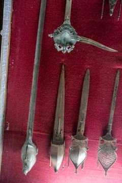 A collection of old metal objects, including a pair of scissors and a sword.. Stock Photos