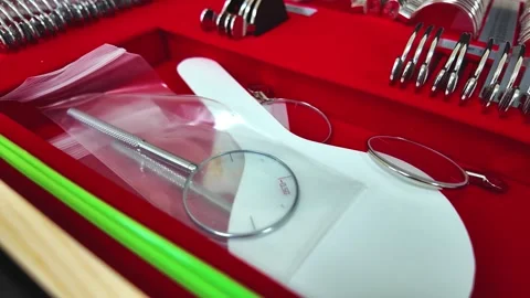 A collection of optical tools and accessories arranged in a vibrant red display Stock Footage 303373964