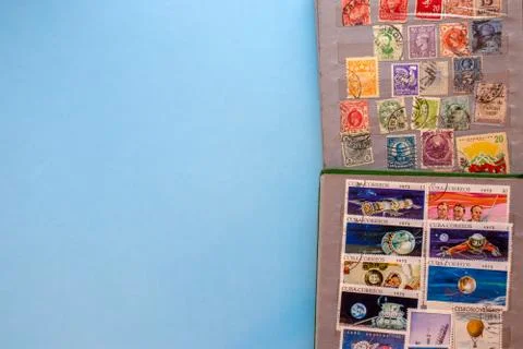 A collection of post stamps in two post albums on blue background. Top view Stock Photos