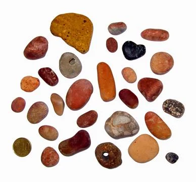 Collection of reddish brown pebbles and hag stones with a cent coin placed .. Stock Photos