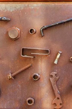 A collection of rusty metal components is resting on a rusty surface Stock Photos
