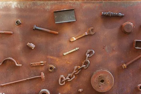 A collection of rusty metal components is resting on a rusty surface Stock Photos