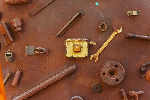 A collection of rusty metal components is resting on a rusty surface Stock Photos