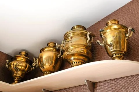 Collection of samovars. Several large yellow samovars on a shelf Stock Photos