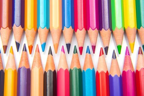 A collection of sharpened colored pencils in a grid pattern on a white back.. Stock Photos