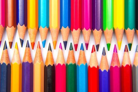 A collection of sharpened colored pencils in a grid pattern on a white back.. Stock Photos