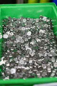 Collection of shiny round silver sequins in a green storage container durin.. Foto stock