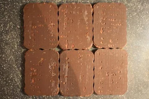 A collection of six rectangular chocolate bars with uneven surfaces Фото