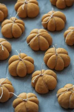 Collection of small decorative pumpkin shaped baked goods tied with twine o.. Stock Photos