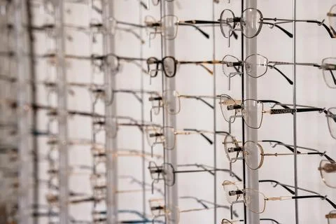 Collection of stylish eyeglasses frames hanging on a modern display rack in.. 写真素材