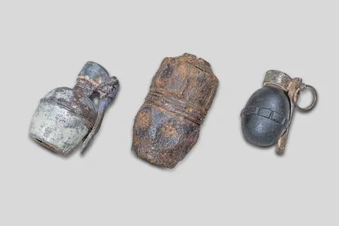 A collection of three antique artillery shells, arranged on a plain backgroun 스톡 사진