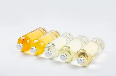 Collection transparent lying bottles with different pale colors liquid, cosme Stock Photos