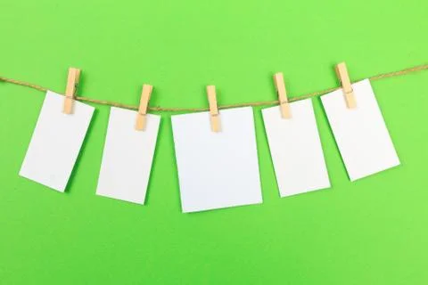 Collection of various notes and a clothes pegs on green background with clipp Stock Photos