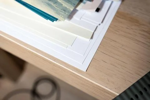 A collection of various sheets of paper and photographic prints stacked on a 写真素材