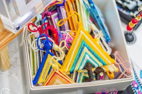 Collection of vibrant, intricately patterned triangular lanterns in a glass d 스톡 사진