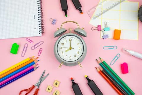 A collection of vibrant study supplies featuring an alarm clock set against.. Stock Photos
